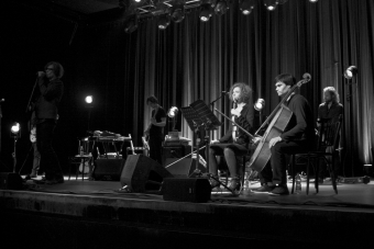Mark Lanegan (l.) mit Orchester auf der Bühne im Linzer Posthof. 